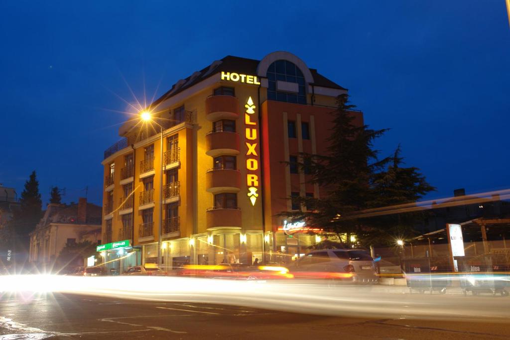 un hôtel avec un panneau sur le côté d'un bâtiment dans l'établissement Hotel Luxor, à Bourgas