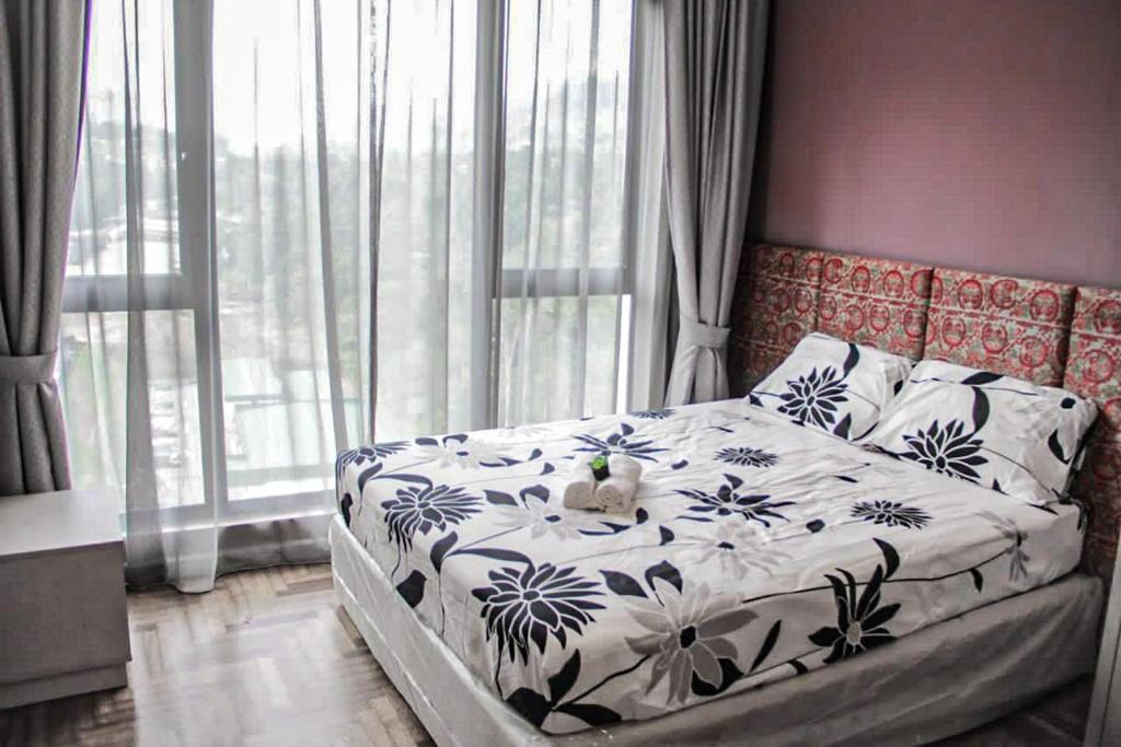 a bedroom with a bed with a blue and white blanket at LUXURIOUS AND COZY @GENTING VISTA 3B3B(FREE WI-FI) in Genting Highlands