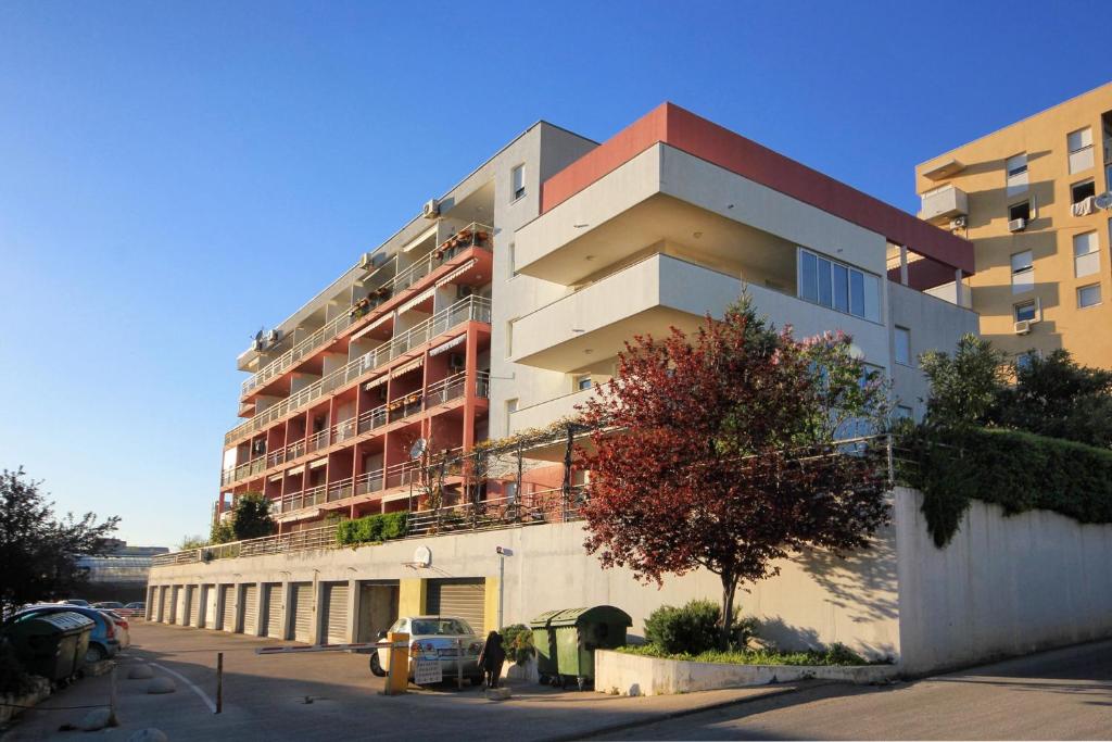 a tall building with a parking lot in front of it at Apartments with a parking space Split - 8681 in Split