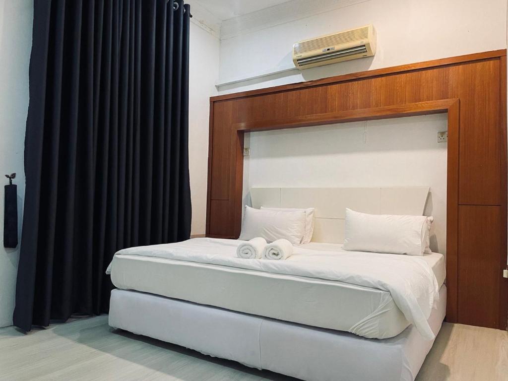 a bedroom with a bed with two towels on it at Deluxe Room in Pendang