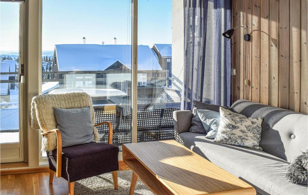 uma sala de estar com um sofá, uma cadeira e uma janela em Sjusjen Fjellstue Leil Nr 201 em Sjusjøen
