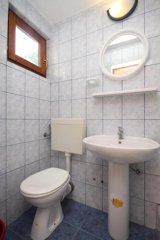 a bathroom with a toilet and a sink and a mirror at Studio Rukavac 8863a in Rukavac