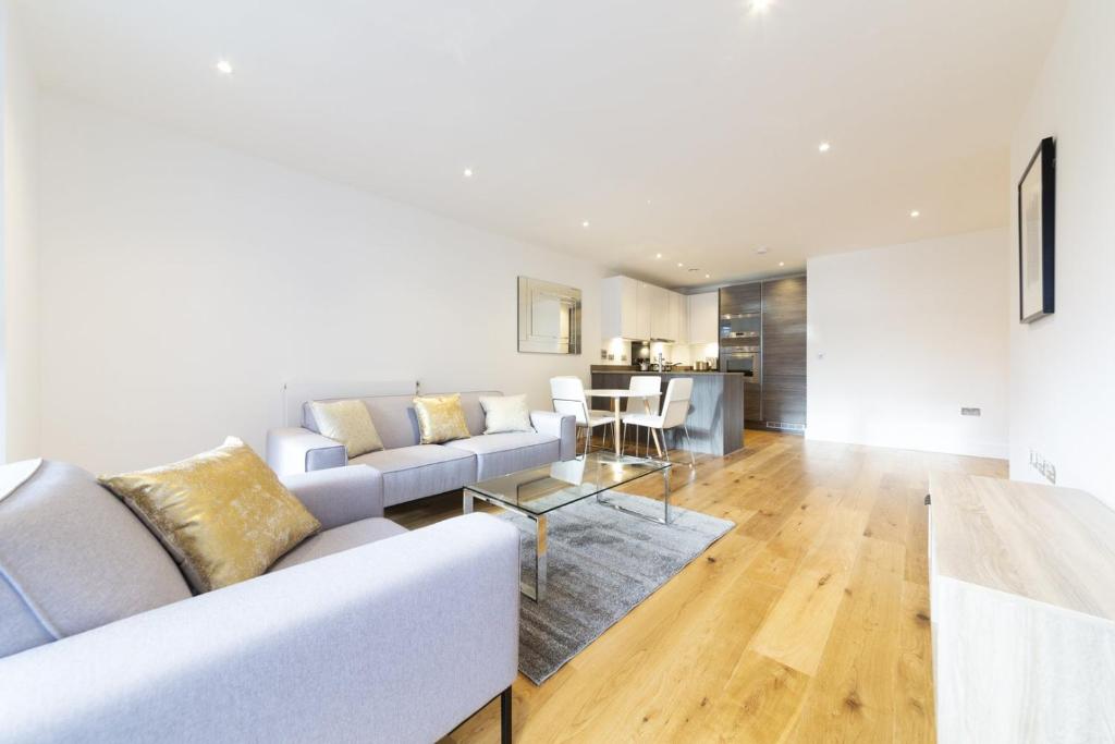 a living room with a couch and a table at Stylish family sized 2 bedroom apartment in London