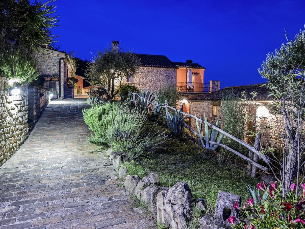 einen Steinweg, der nachts zu einem Haus führt in der Unterkunft Belvilla by OYO Santa Caterina in Monte San Martino
