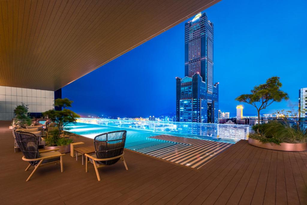 高雄的住宿－TAI Urban Resort 承億酒店，建筑在晚上可欣赏到城市天际线的景色