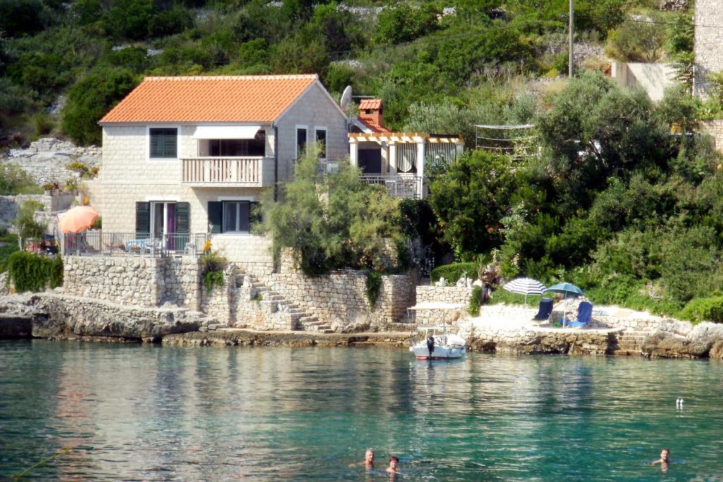 una casa en la orilla de un cuerpo de agua en Apartments by the sea Cove Donja Kruscica - Donja Krusica, Solta - 11146 en Grohote
