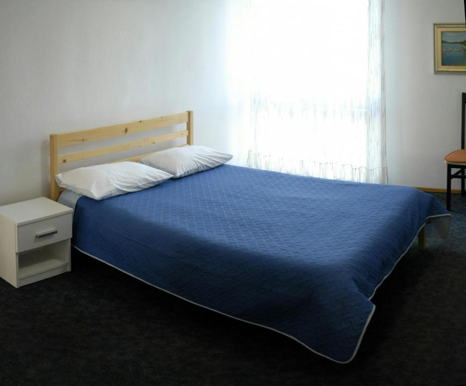 a bedroom with a bed with a blue blanket and a window at Apartments with WiFi Split - 11312 in Split
