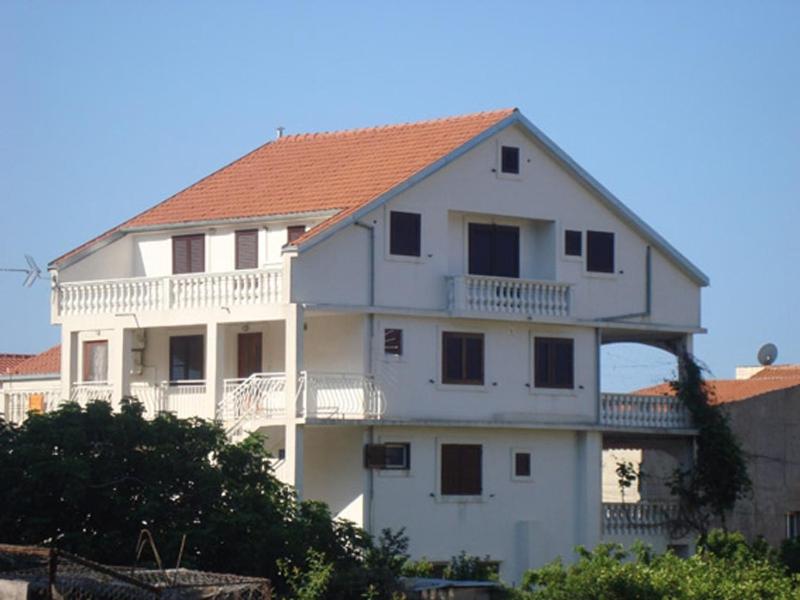a large white building with a red roof at Apartments and rooms with WiFi Komiza, Vis - 11315 in Komiža