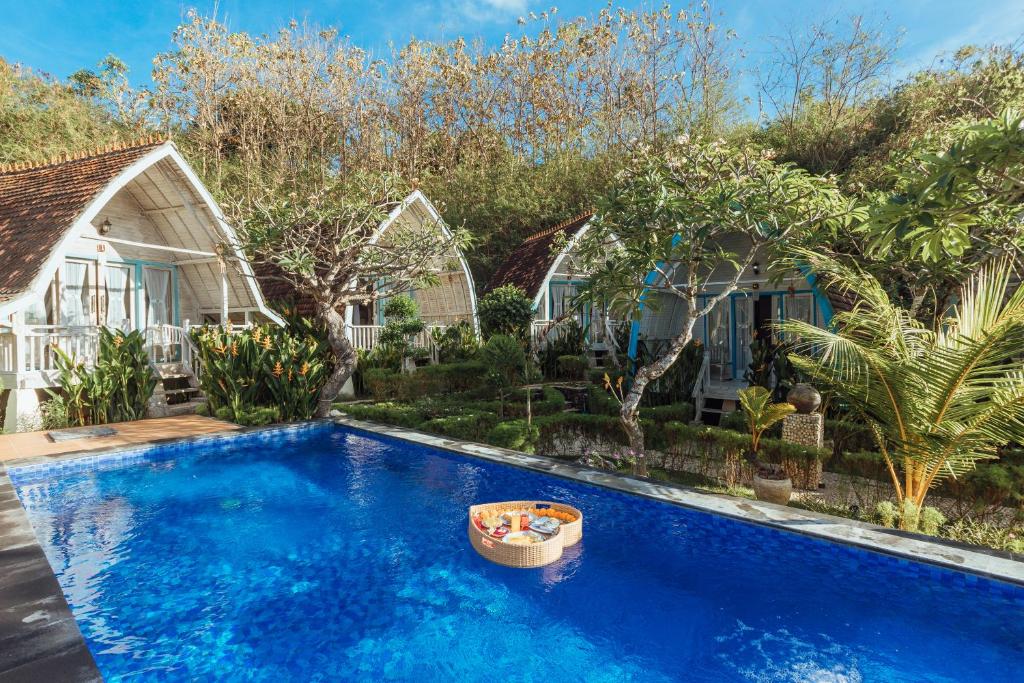 - une piscine en face d'une maison dans l'établissement Bakung Cozy Cottage, à Nusa Penida