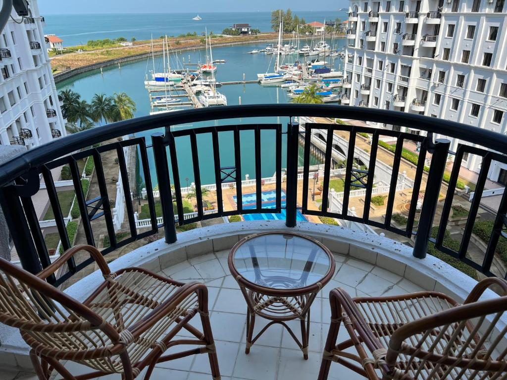a balcony with chairs and a view of a marina at Sevenseas Marina Crescent in Port Dickson