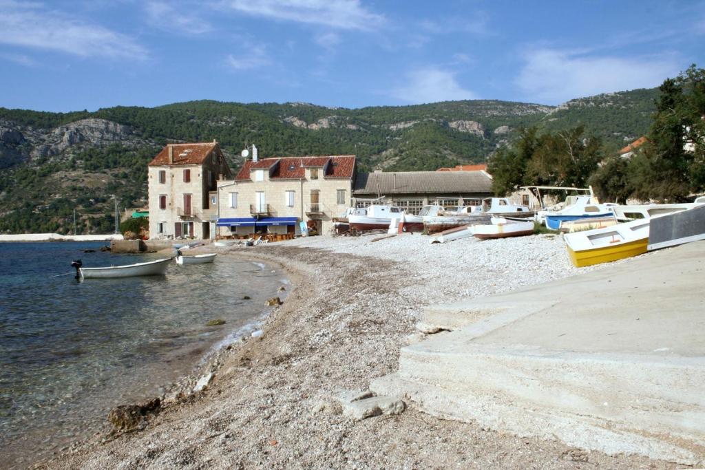 a group of boats on the shore of a beach at Apartments with a parking space Komiza, Vis - 12325 in Komiža