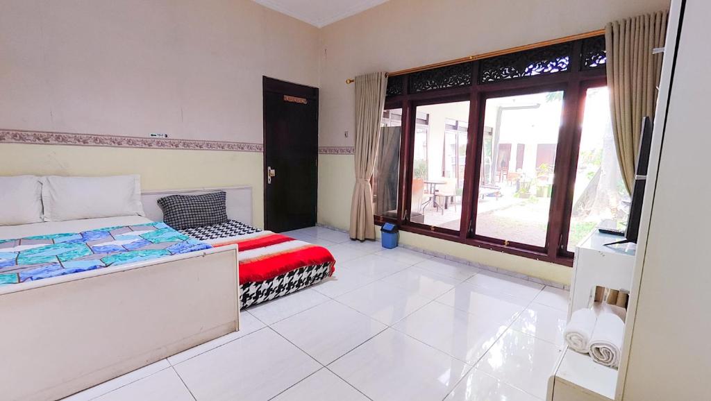 a bedroom with a bed and a window at Homey Guesthouse near Sby Zoo Syariah in Surabaya