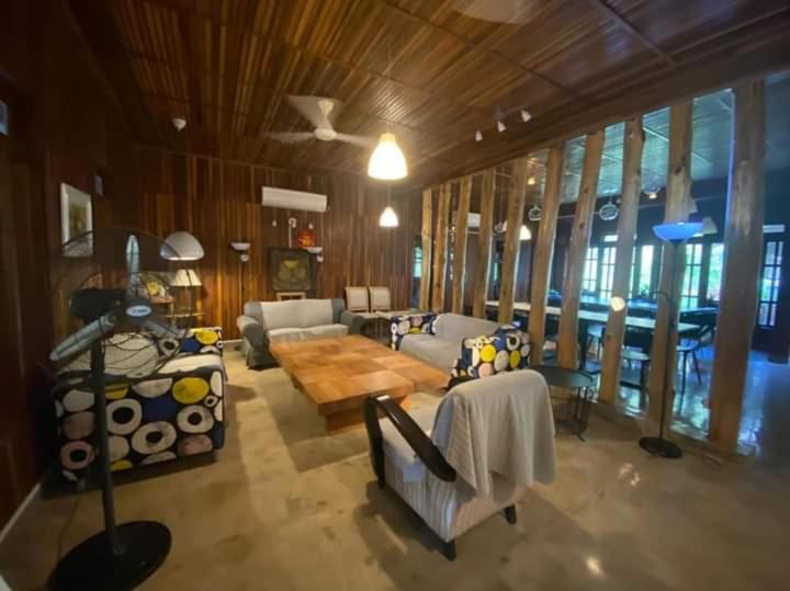 a living room with couches and a table and windows at Jimmy Durian Orchard in Karak