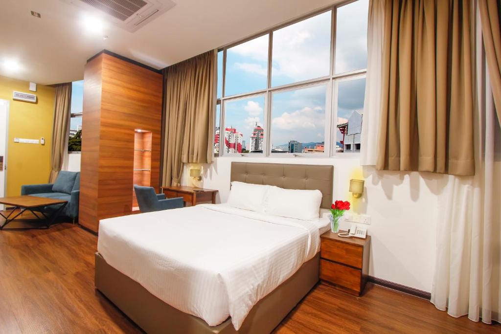 Una habitación de hotel con una cama y una ventana grande. en CitiVilla Hotel Penang, en George Town
