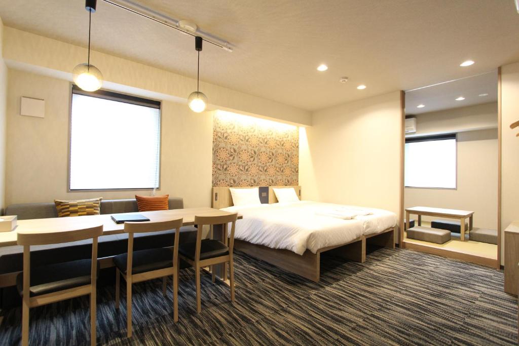 a hotel room with a bed and a table and chairs at KOKO HOTEL Residence Asakusa Tawaramachi in Tokyo
