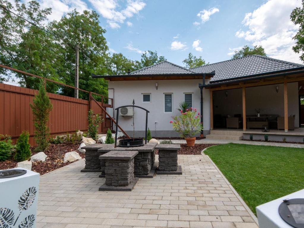 a backyard with a barbecue grill and a house at Levendula vendégház in Szentes