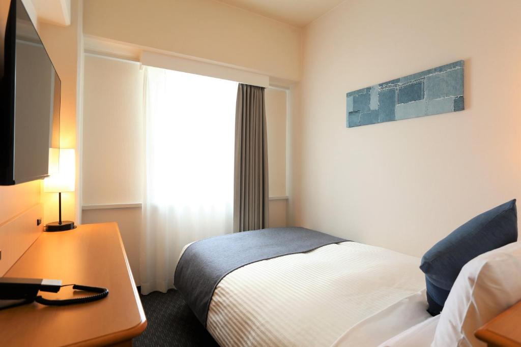 Postel nebo postele na pokoji v ubytování HOTEL MYSTAYS Okayama
