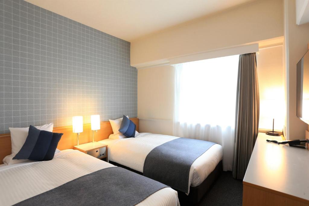 Postel nebo postele na pokoji v ubytování HOTEL MYSTAYS Okayama