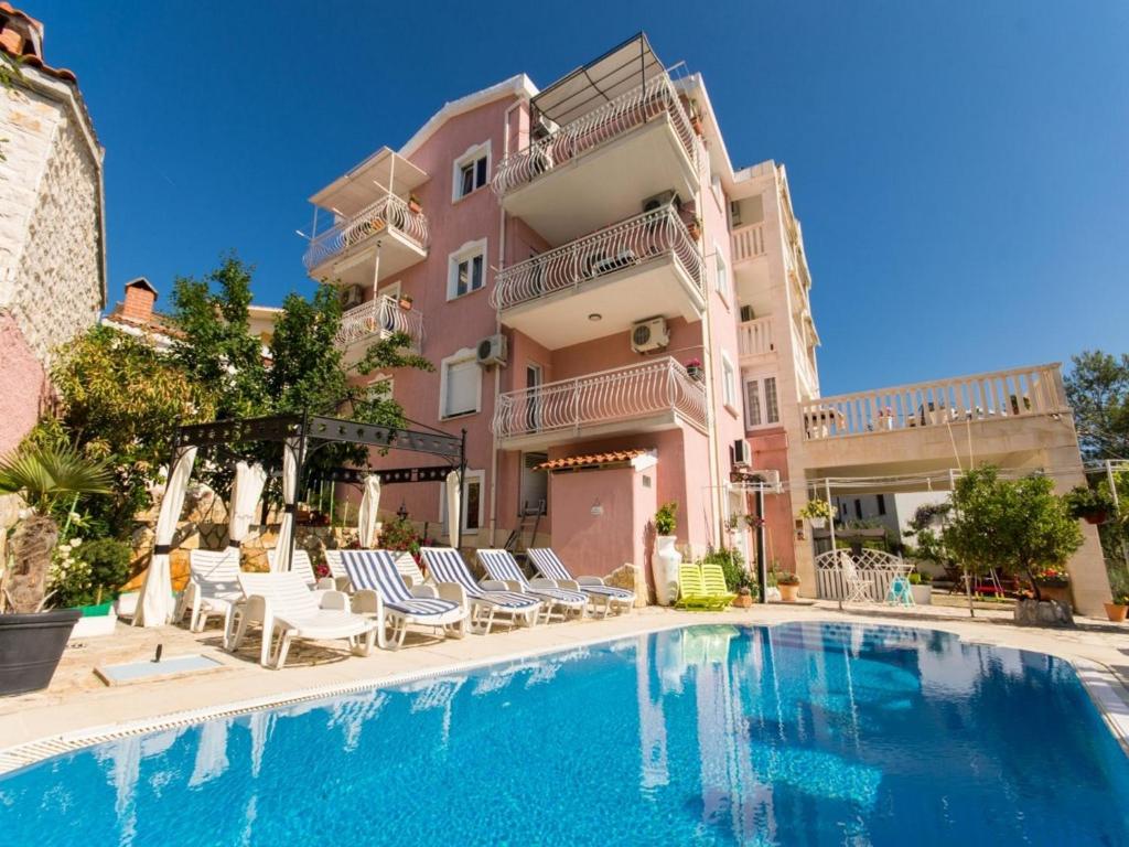 un hotel con piscina frente a un edificio en Villa Stil, en Trogir