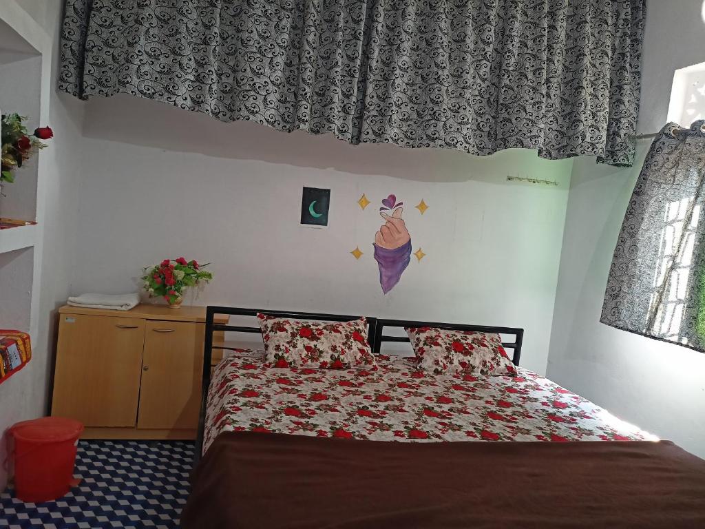 1 dormitorio con 1 cama y una ventana con cortinas en Holiday Home Stay en Khajurāho