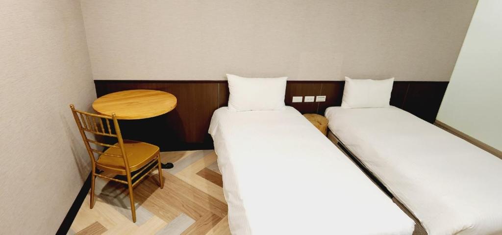 Postel nebo postele na pokoji v ubytování 喜園旅館Ximen Garden Inn