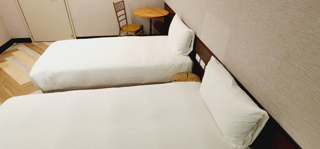 Postel nebo postele na pokoji v ubytování 喜園旅館Ximen Garden Inn