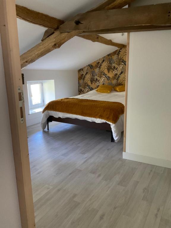 a bedroom with a bed in a attic at Ravissant appartement dans cadre verdoyant in Marchampt