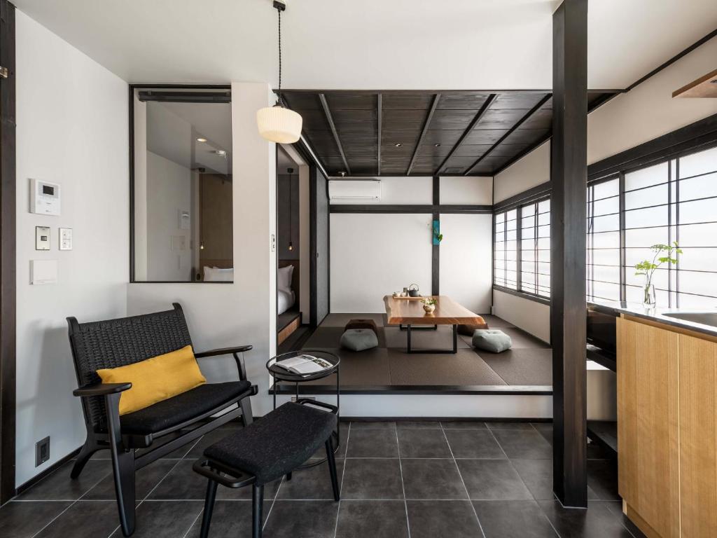 ein Wohnzimmer mit einem Stuhl und einem Tisch in der Unterkunft Sansuikyo Machiya House in Kanazawa