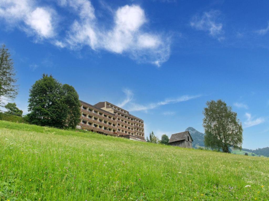 a building on top of a hill with a grassy field at Beautiful apartment in Tauplitz with terrace in Tauplitz