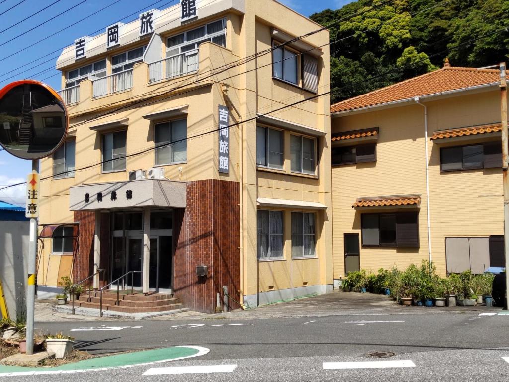 a building on the corner of a street at Yoshioka Ryokan in Kamogawa