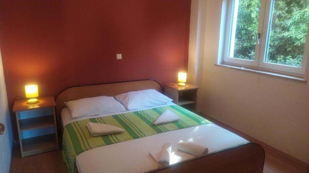 a small bedroom with a bed with two lamps at Villa Toni in Sveti Filip i Jakov