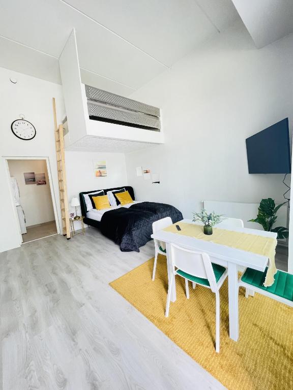 a white living room with a table and a couch at aday - Harbor Groundfloor Own Entrance - Studio in Aalborg