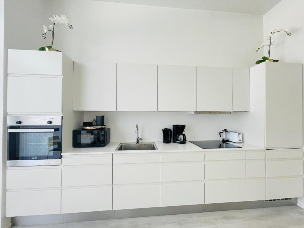 a white kitchen with white cabinets and appliances at aday - Harbor Groundfloor Own Entrance - Studio in Aalborg