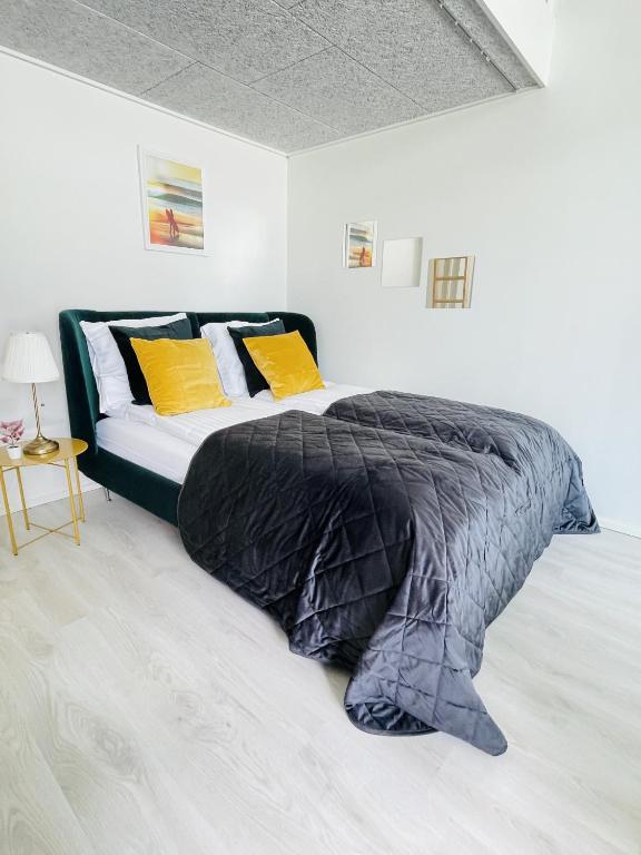 a bed with a black comforter in a room at aday - Harbor Groundfloor Own Entrance - Studio in Aalborg