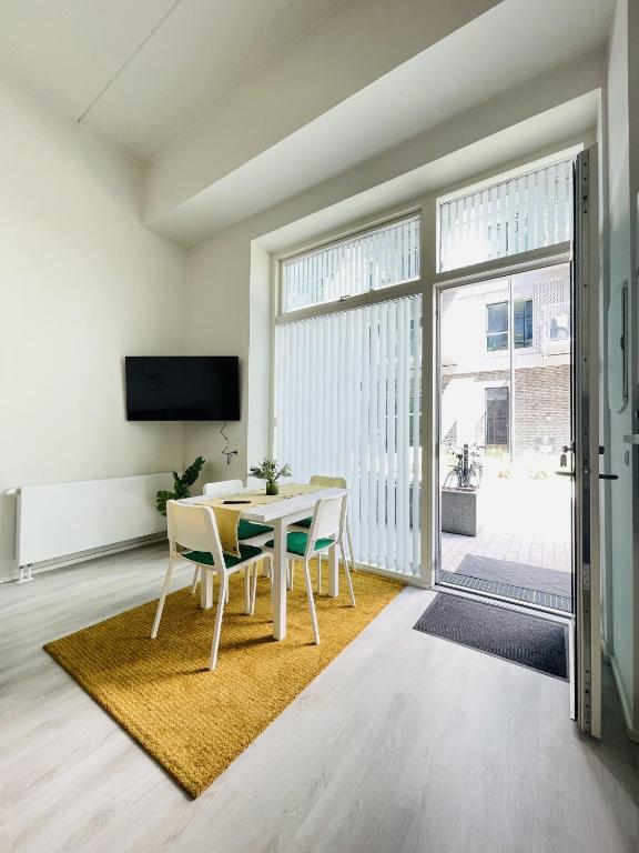 a dining room with a table and chairs and a large window at aday - Harbor Groundfloor Own Entrance - Studio in Aalborg