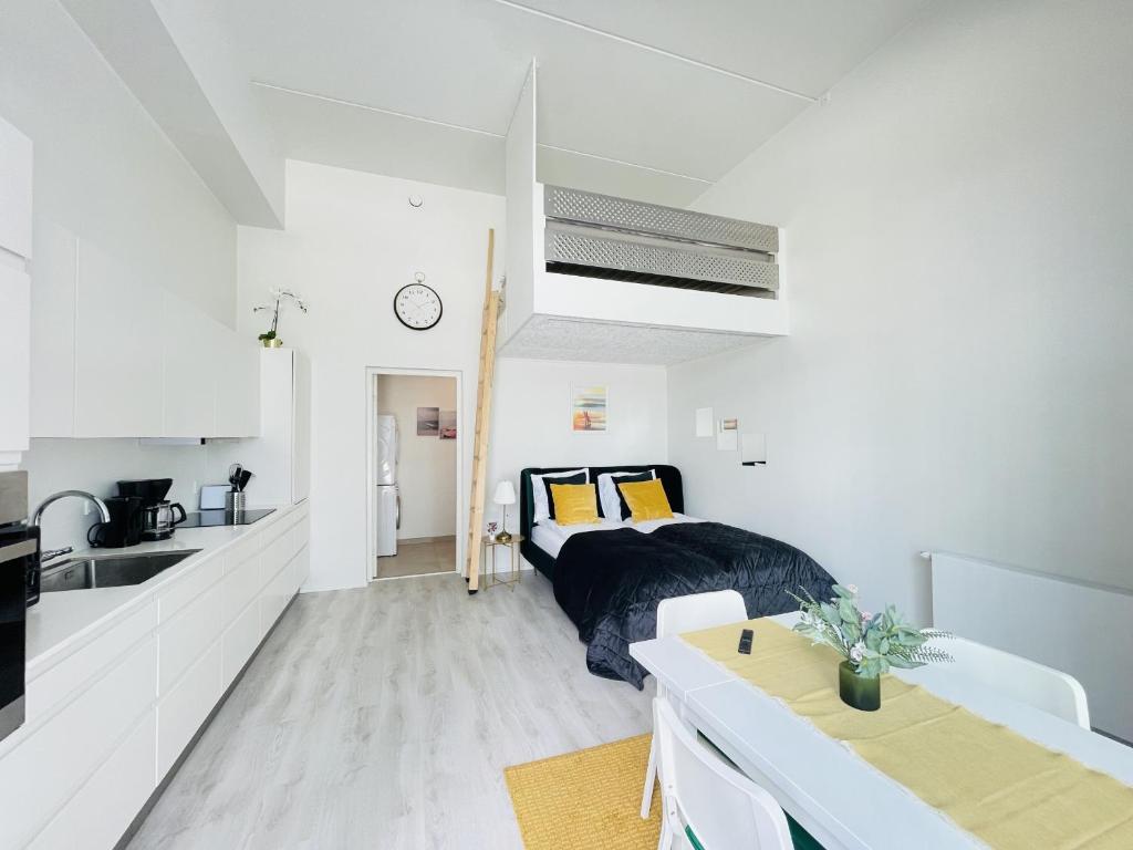 a bedroom with a bed and a kitchen with a sink at aday - Harbor Groundfloor Own Entrance - Studio in Aalborg