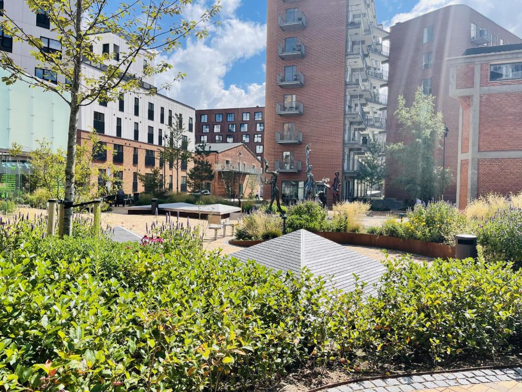 a garden in a city with tall buildings at aday - Harbor Groundfloor Own Entrance - Studio in Aalborg