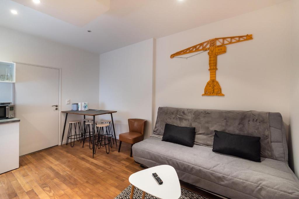 a living room with a couch and a cross on the wall at La Grue Jaune in Nantes