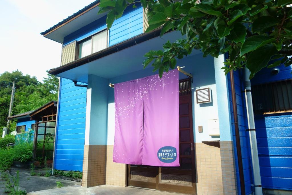 a purple banner hanging on the side of a house at 星降るゲストハウスー奥琵琶湖マキノ1日1組限定の1棟貸しプランー in Kaizu