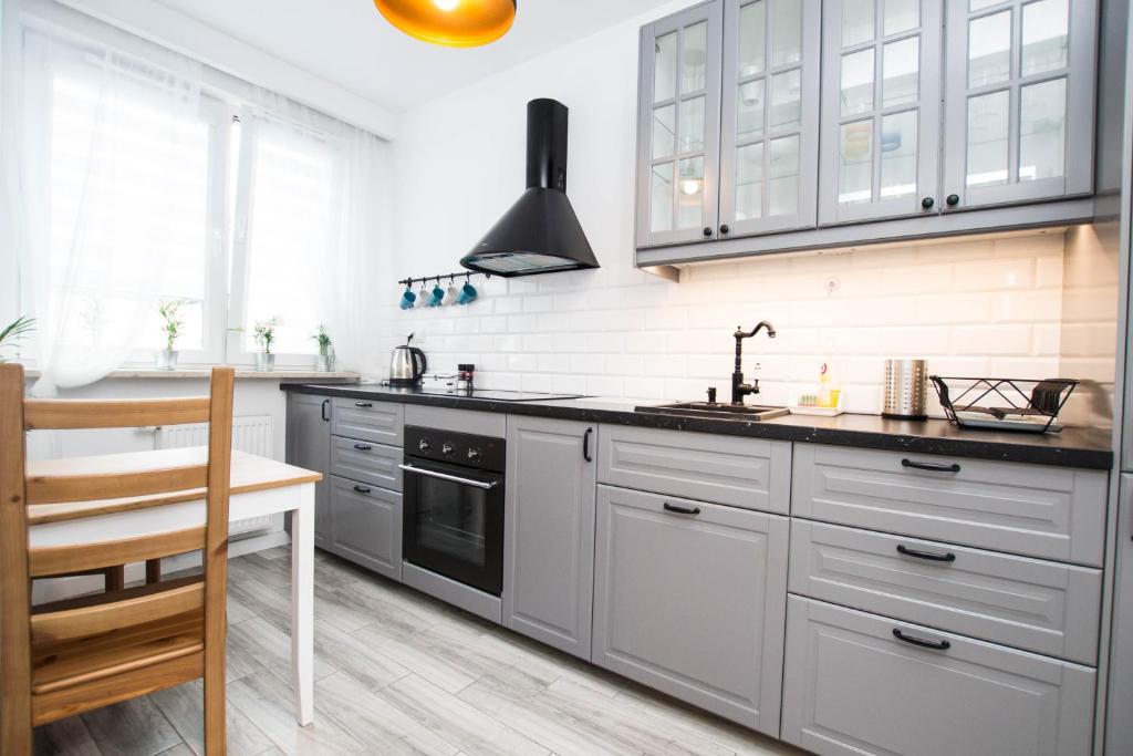 a kitchen with white cabinets and a sink at WAW Apartamenty Cybernetyki in Warsaw