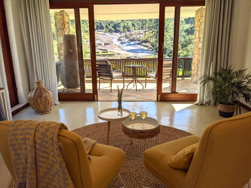 a living room with two chairs and a table at Silverstone Lodge in Mbabane