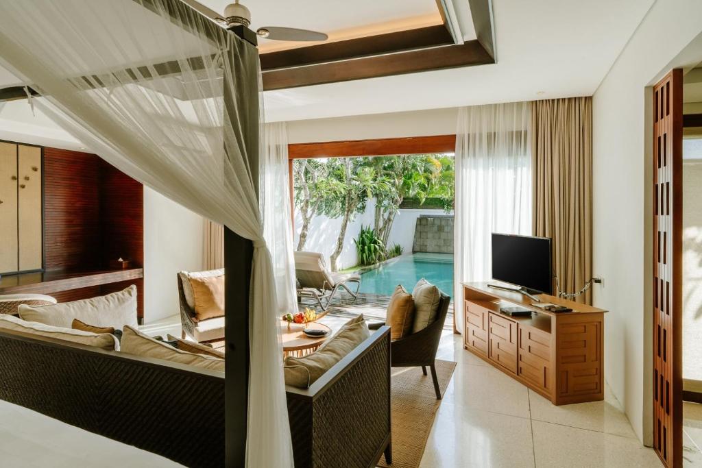 een woonkamer met televisie en een woonkamer met zwembad bij The Samaya Seminyak Bali in Seminyak