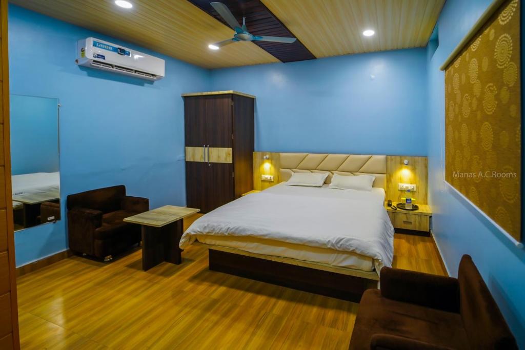 - une chambre avec un lit et un mur bleu dans l'établissement Manas AC Rooms, à Ratlām
