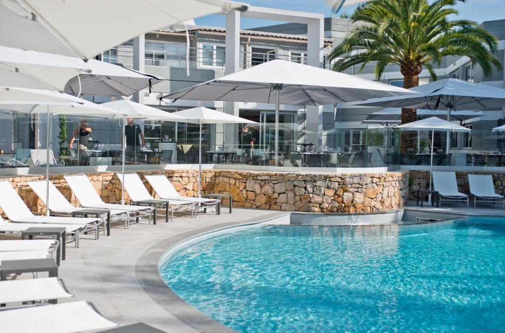 瓦爾邦訥的住宿－索菲亞安提波利斯金色鬱金香spa酒店，一个带躺椅和遮阳伞的游泳池