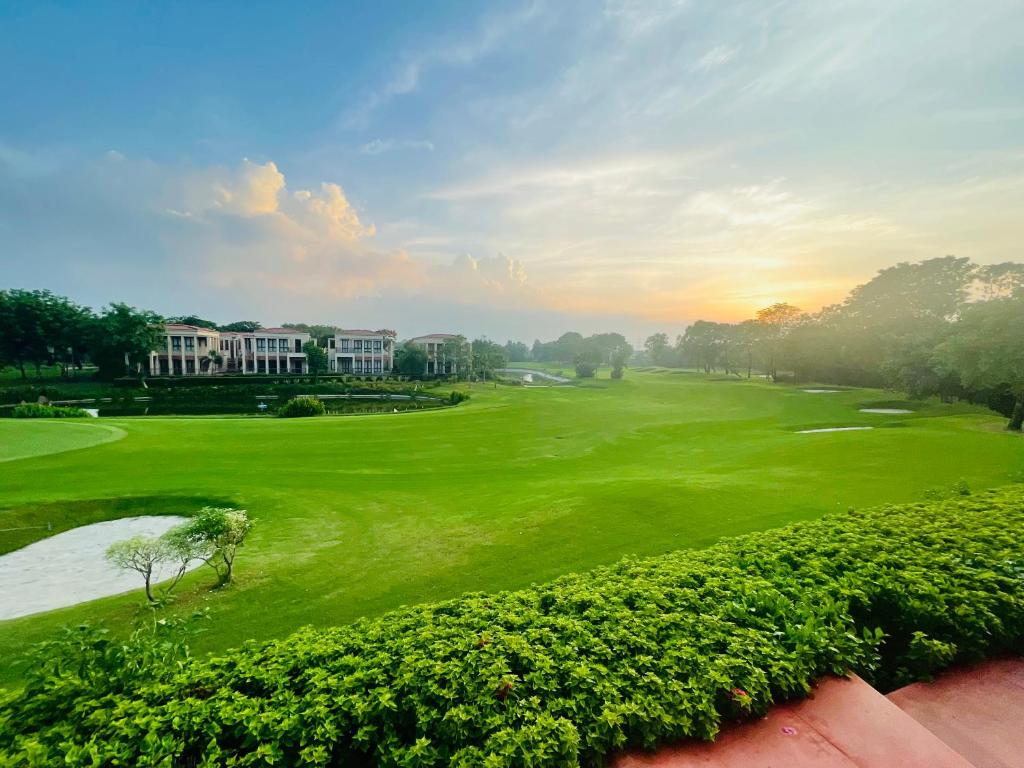 - une vue sur un parcours de golf avec un green dans l'établissement Beautiful Apartments at Tarudhan Valley Golf Resort, Manesar, à Gurgaon