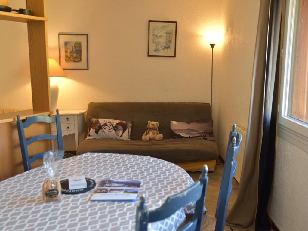 une chambre avec un lit et un canapé avec un chien en peluche dans l'établissement Appartement cosy 2 pièces au pied des pistes, parking et casier à skis - FR-1-266-62, à Montgenèvre