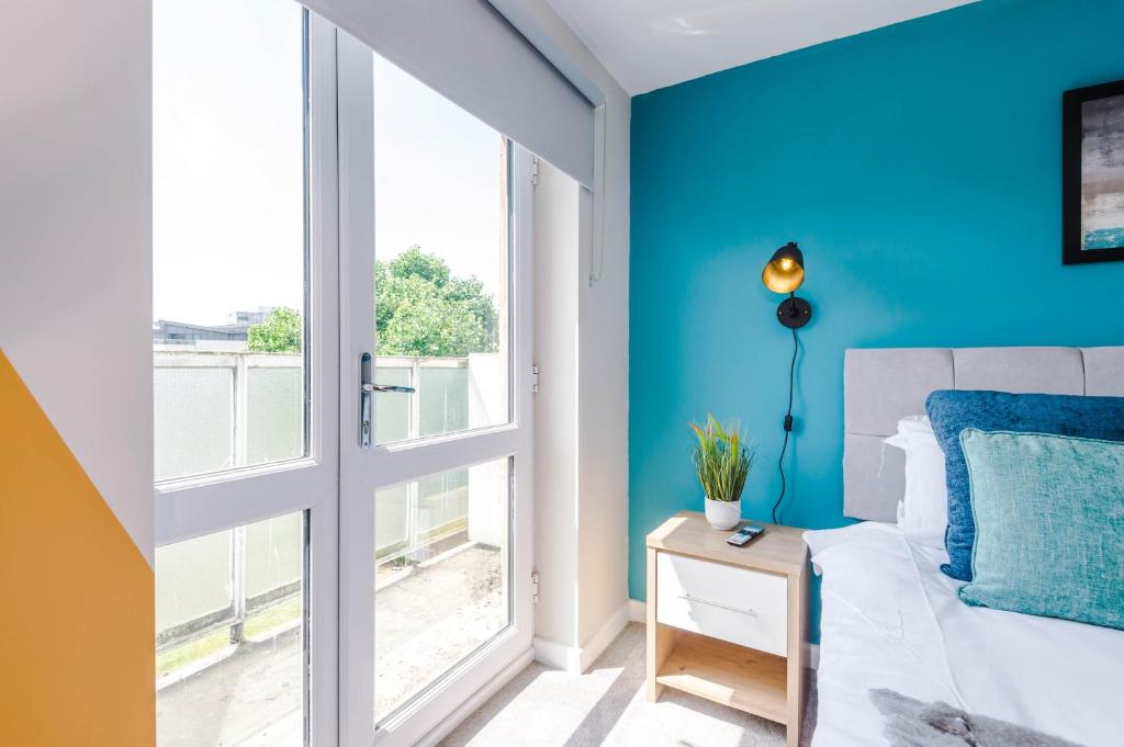 a bedroom with blue walls and a bed and a window at Hidden Gem within Central Chester - Great Location in Chester