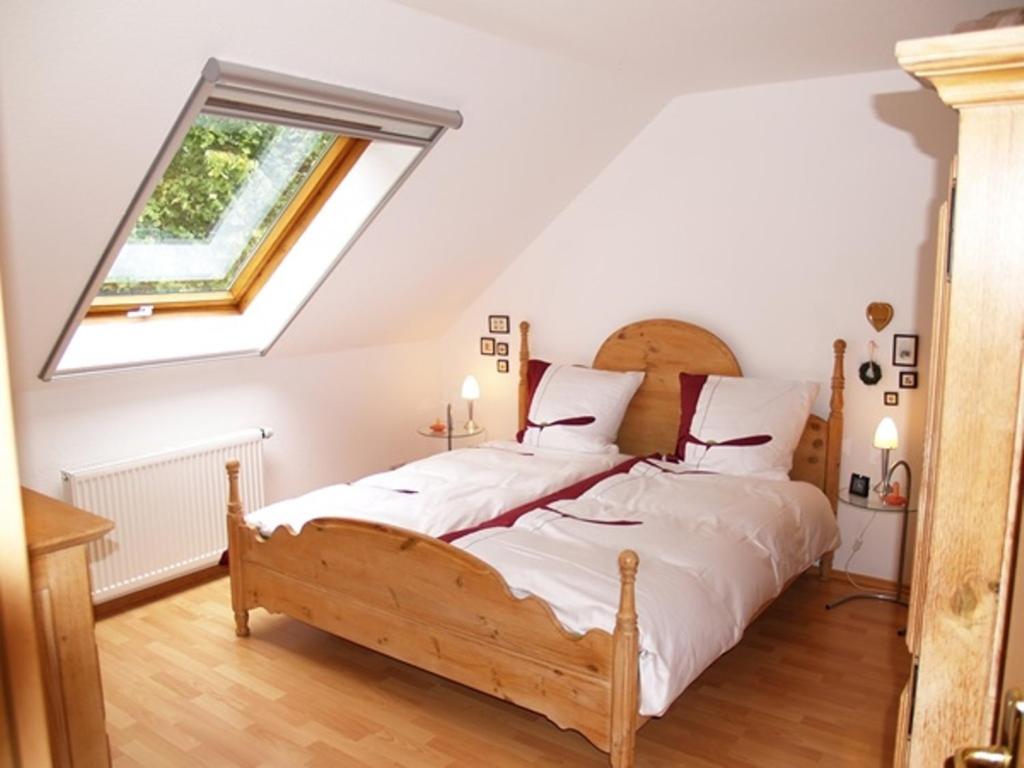 een slaapkamer met een groot bed en een dakraam bij Komfort-Ferienwohnungen Walkmühle in Münstermaifeld