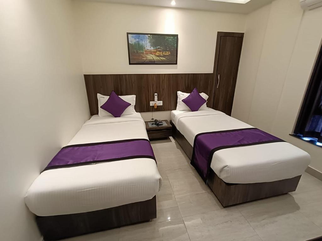 Postel nebo postele na pokoji v ubytování Sheldon Inn Kolkata