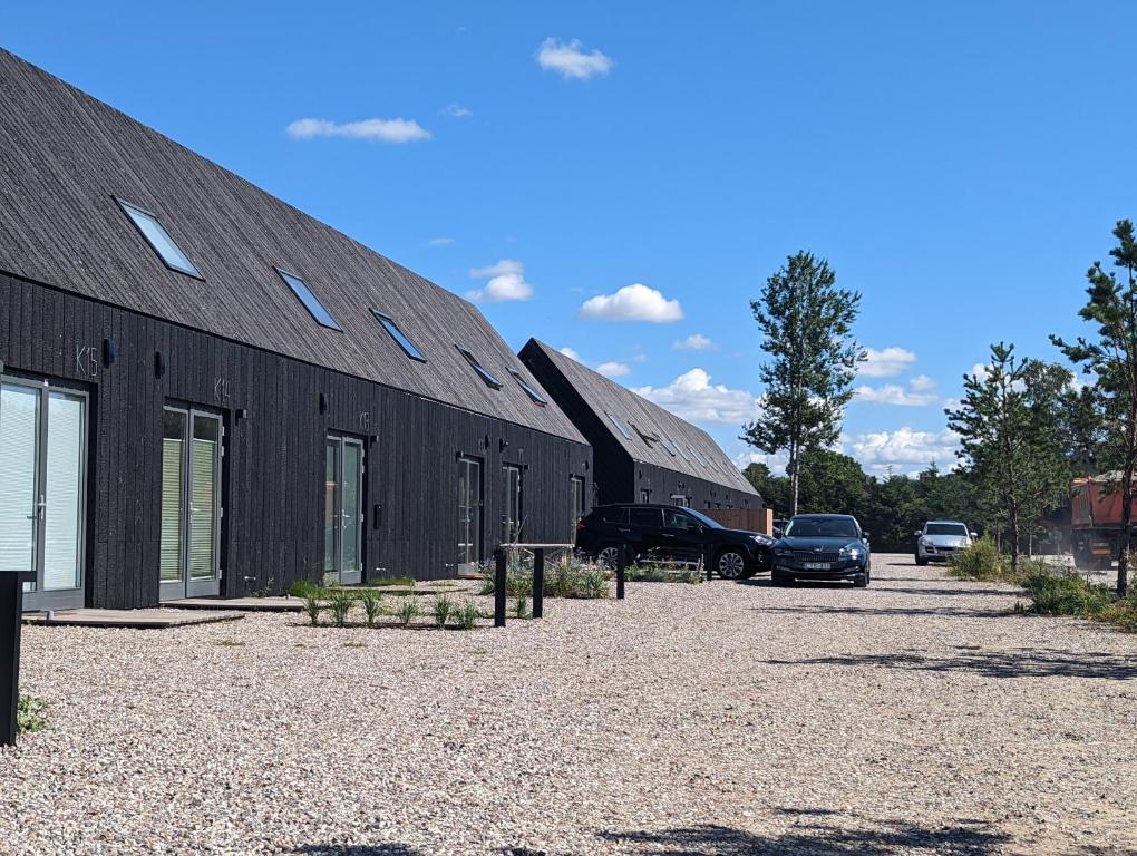a building with cars parked in a parking lot at Svencelė K-17 in Svencelė